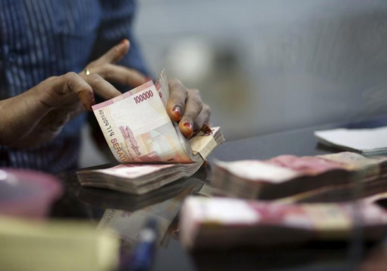 资料图片:2015年6月,印尼雅加达,货币兑换店雇员清点卢比现钞。REUTERS/Nyimas Laula